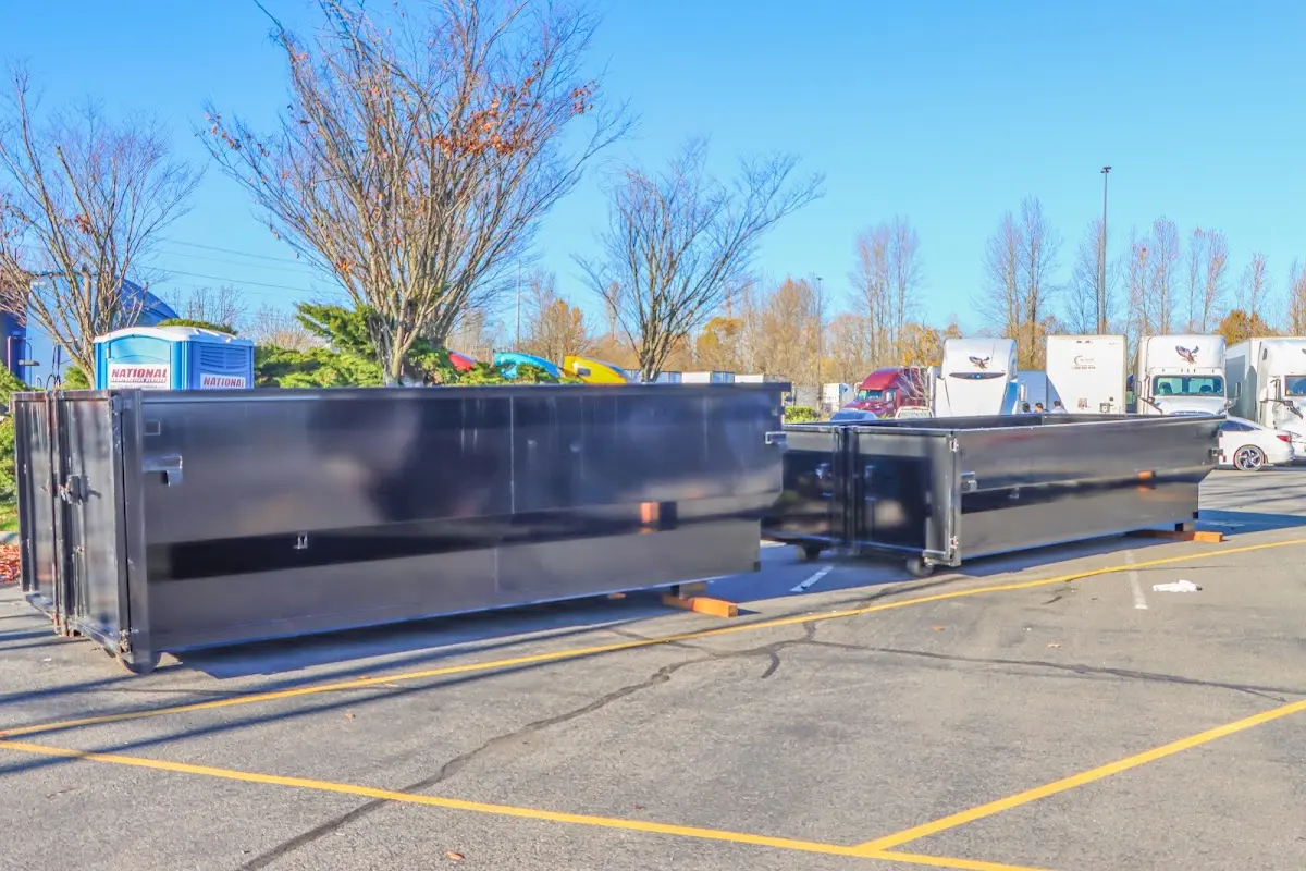 Professional dumpster rental service with roll-off container on residential driveway in Larchmont